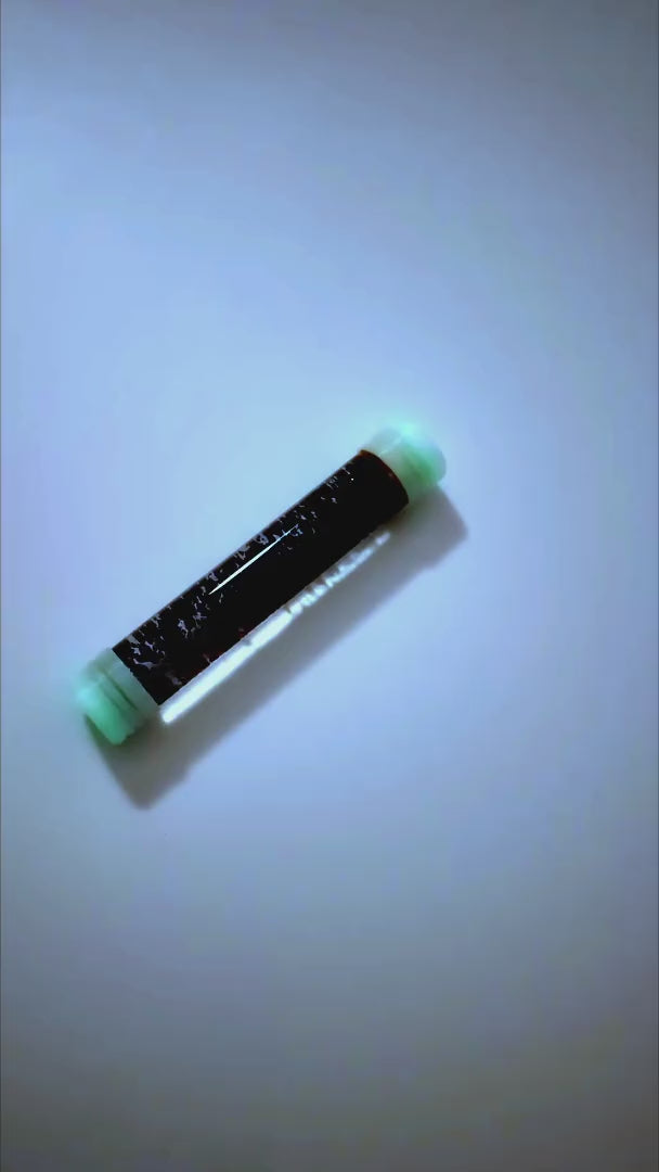Flacon à bouchons blancs phosphorescents, lumière allumée puis bouchons verts lumineux dans le noir